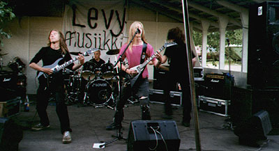 Bändi ulkoilmakeikalla Taipalsaarella 1999, basistina Alander.